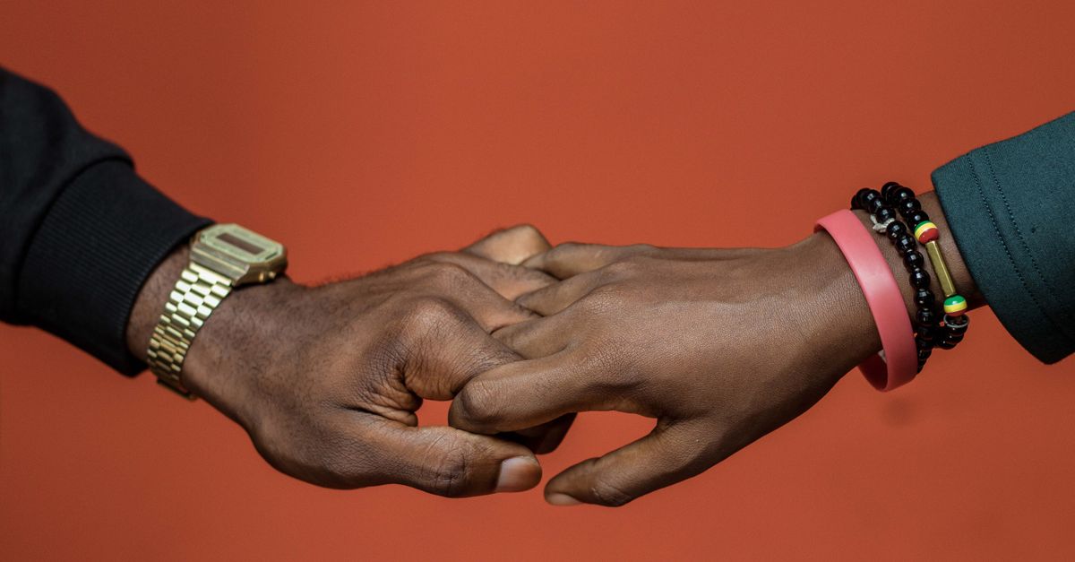 Two African American hands holding each other, symbolizing unity and love.