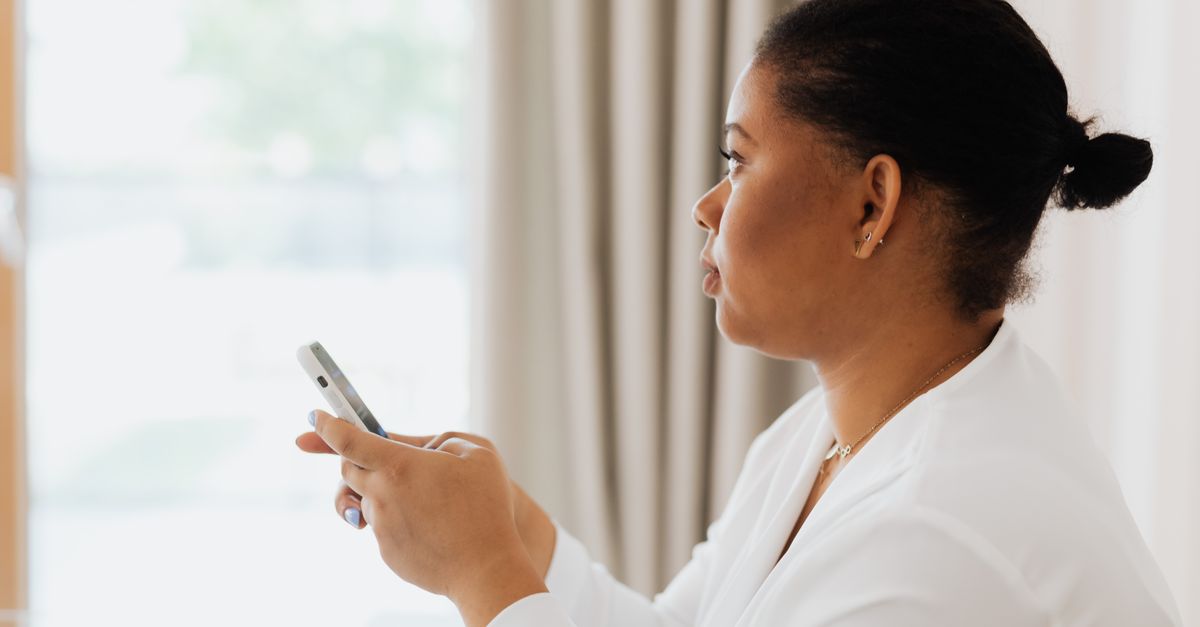A professional woman using her smartphone indoors, focused on work.