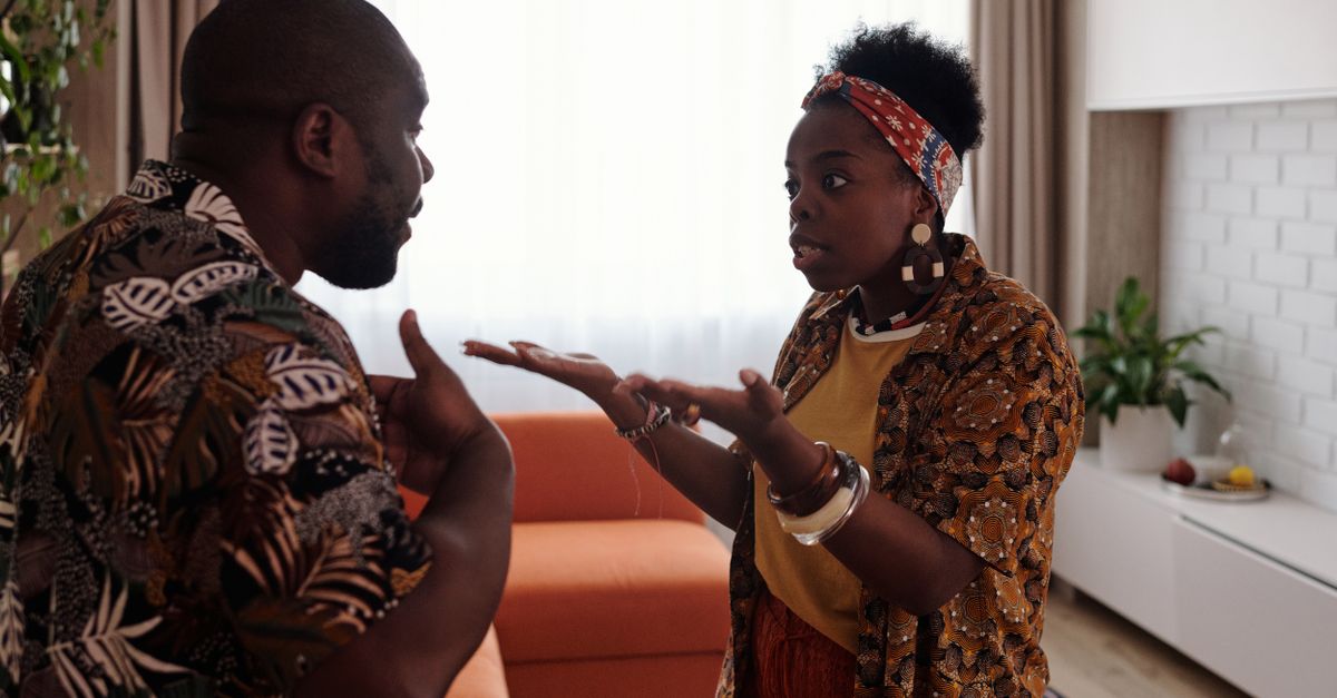 A couple arguing passionately in their living room, expressing emotions and gestures.